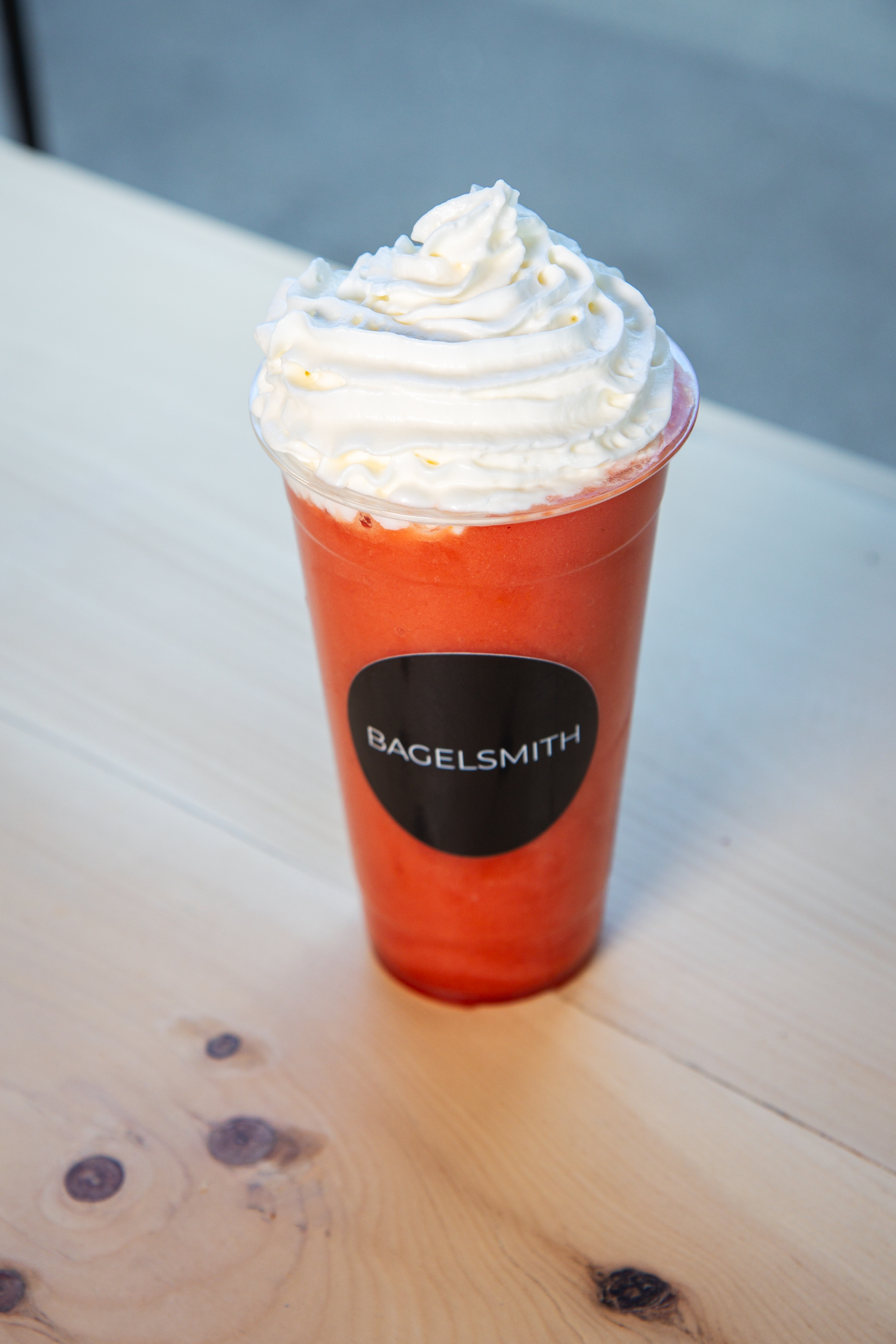 Strawberry smoothie with whipped cream in Bagelsmith cup